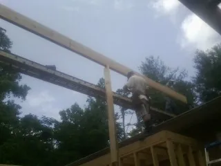 Carpenter setting a ridge beam over a new addition frame — Ice Dam Removal by Roofing Brothers in Chugwater