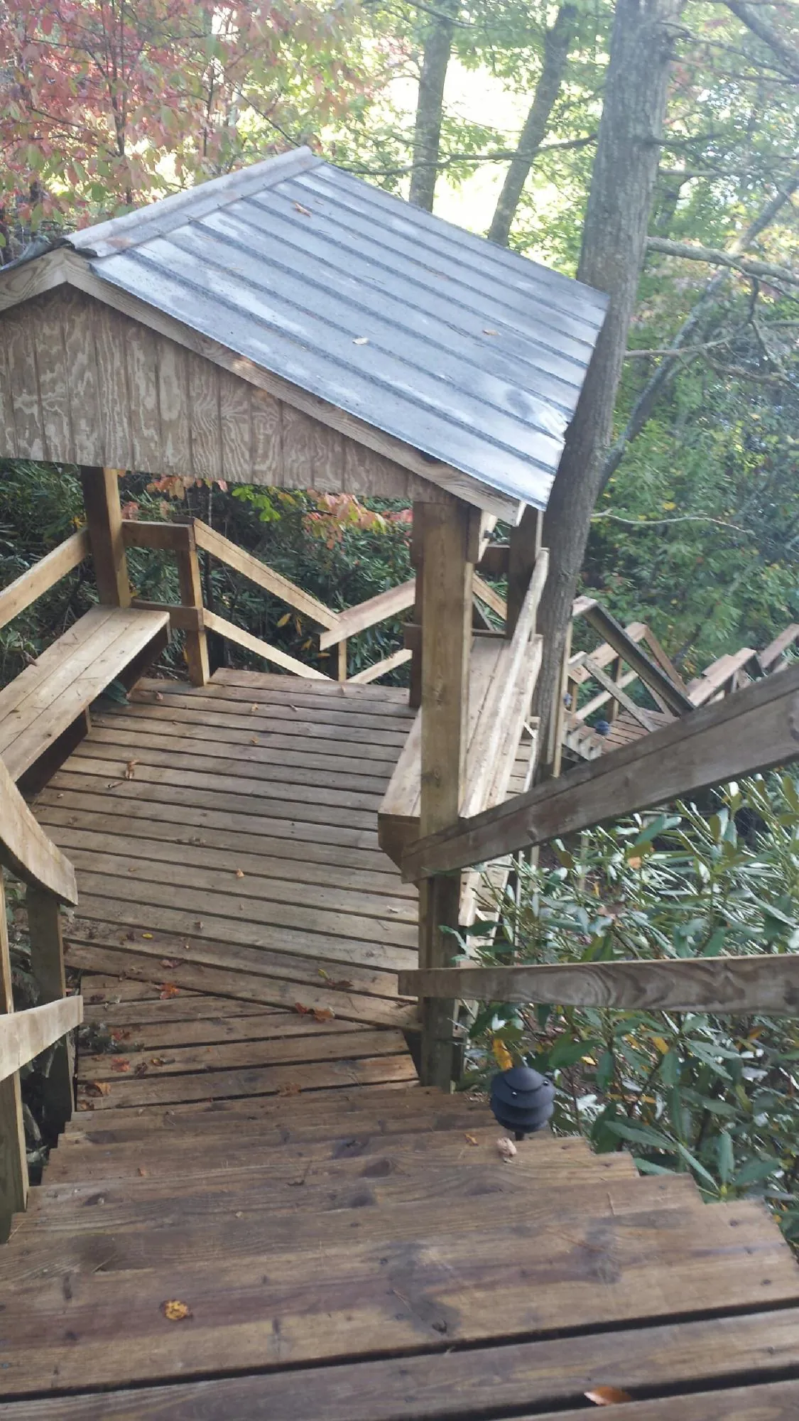 Metal roofed shelter over wooden steps on a wooded walkway — Skylight Repair & Installation work by our crew in Chugwater
