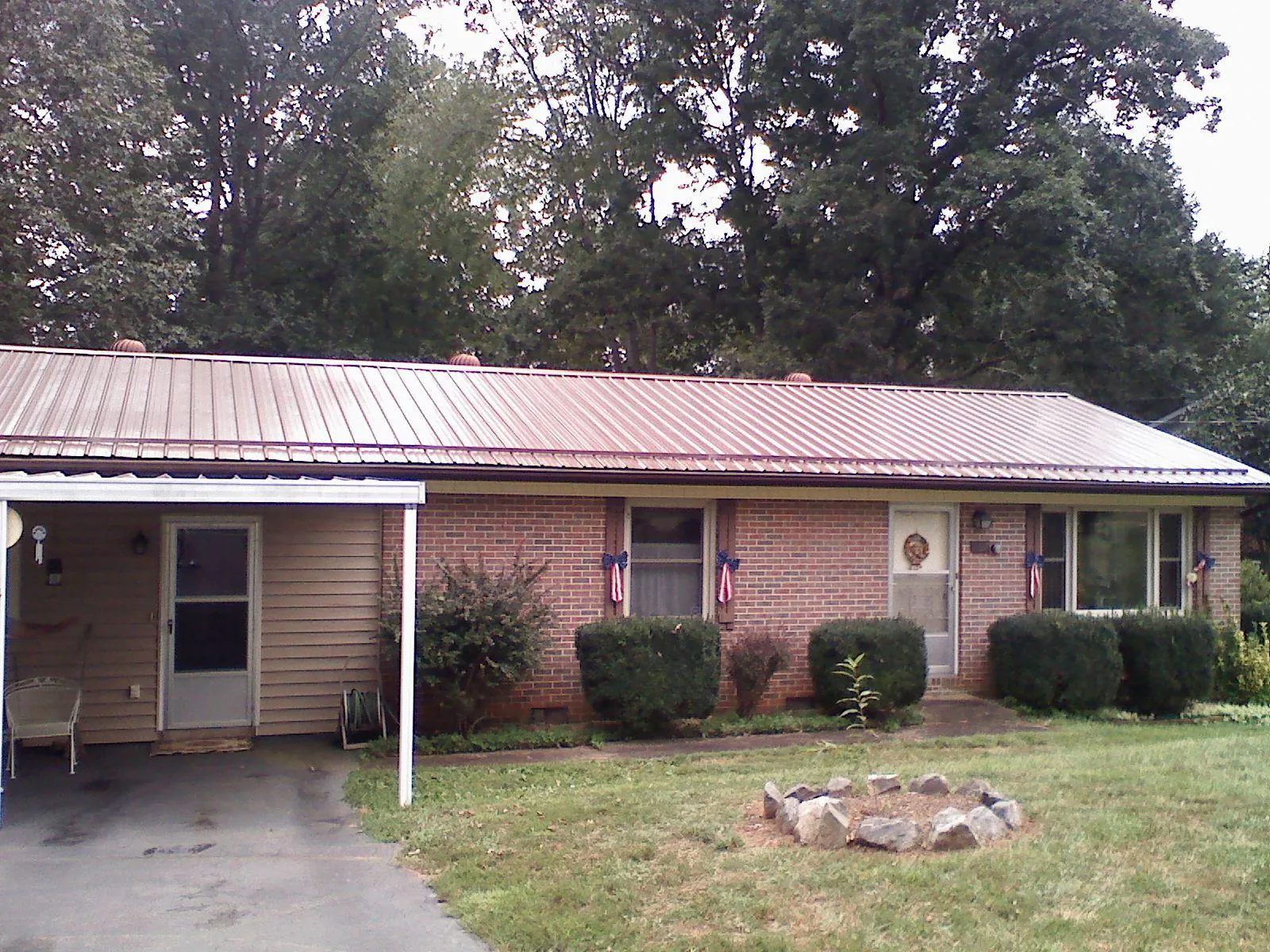 Bronze metal roof and carport on a brick ranch home — Roof Repair work by our crew in Chugwater